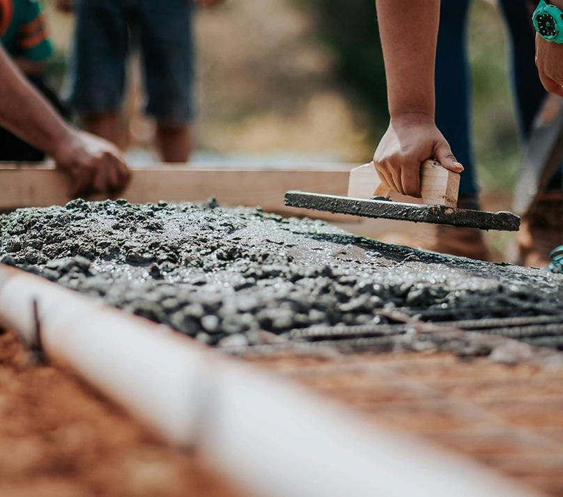 A person is working on the ground with cement.